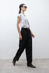 Pantalón negro de vestir, tiro alto, con pinzas frontales y corte ancho y holgado.