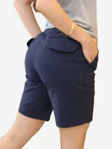 Bermuda de gabardina color azul marino, con cintura elástica y cordón ajustable. Presenta bolsillos laterales y bolsillos traseros con solapa.