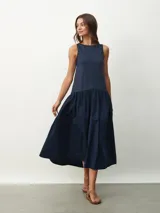 Vestido midi azul marino, sin mangas, con corte recto en la parte superior y falda amplia fruncida.