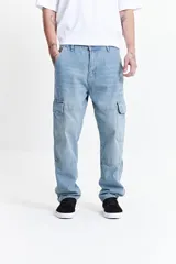 Pantalón cargo color beige, de corte recto, con bolsillos laterales y traseros. Se ajusta a la cintura con cinturón de cuero marrón.