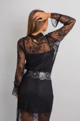 Conjunto de encaje negro, compuesto por una blusa semitransparente de manga larga con cuello alto y una falda midi recta con viso a tono.