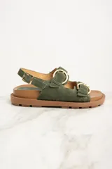 Sandalias de gamuza verde con dos tiras anchas sobre el empeine, hebillas doradas y tira trasera ajustable.