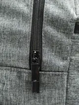 Mochila negra de poliéster con un compartimento principal grande con cierre, un compartimento frontal pequeño con cierre y un bolsillo lateral abierto con elástico.