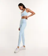 Conjunto deportivo celeste compuesto por un top con tirantes finos y calzas largas con cintura alta y recortes en las rodillas.