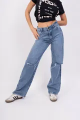 Pantalón de jean celeste de corte wide leg con roturas en las rodillas.