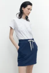 Falda deportiva azul con short incorporado, cintura elastizada con cordón ajustable y bolsillos laterales.