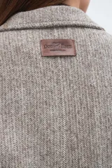 Tapado corto entallado color marrón claro con textura de espiga, cuello solapa y manga larga. Cierre frontal con botones.