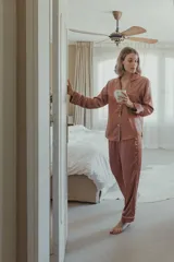 Pijama de satén celeste con vivos en contraste. Incluye camisa de manga larga con botones y pantalón recto con elástico y lazo en la cintura.