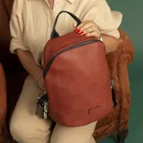 Mochila negra de símil cuero, con cierre principal y bolsillo interno con cierre. Tiene asa de mano, correas regulables y bolsillo oculto en la espalda.