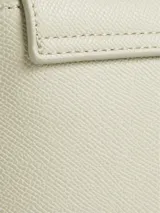Cartera de hombro color crema, marca Calvin Klein, modelo CK Must. Tiene correa de hombro ajustable con el logo de la marca y otra correa más fina.