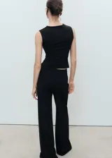 Top sin mangas color negro, de tejido elástico y diseño entallado, con escote cuadrado y tirantes anchos.