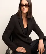 Blazer negro de punto roma con abotonado sencillo, corte entallado y solapas clásicas.