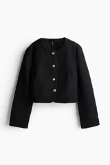 Chaqueta corta negra de bouclé con escote redondo y cierre frontal con botones dorados. Forrada.
