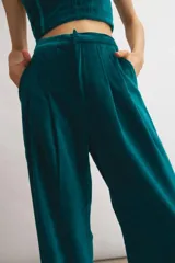 Pantalón de terciopelo azul marino, de corte sastrero amplio con pinzas, bolsillos laterales y largo al tobillo.