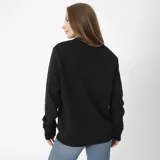 Buzo negro de algodón y poliéster con cuello redondo, mangas largas y puños ajustados. Estampado frontal con el logo de Caterpillar en gris oscuro y logo triangular amarillo en la manga.