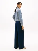 Campera de jean Tommy Hilfiger con rayas verticales celestes y blancas, corte cropped y oversize. Tiene cuello clásico, cierre con botones dorados, dos bolsillos frontales con solapa y logo bordado en la manga.