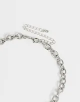 Collar corto dorado con cadena de eslabones gruesos y dijes colgantes: candado con forma de corazón, corazón liso y llave plateados.
