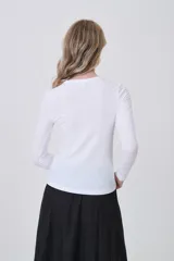 Remera de manga larga ajustada al cuerpo, color negro, con cuello redondo a la base y tejido acanalado.