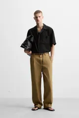 Camisa de hombre relaxed fit con cuello bowling y manga corta, confeccionada en tejido fluido con mezcla de viscosa a rayas verticales en tonos verde y blanco.
