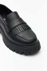 Mocasines negros de símil cuero con plataforma chunky de 4cm y detalle de flecos. 