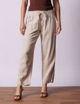 Pantalón largo de lino y rayón a rayas verticales grises y blancas. Tiene pretina elastizada con lazo de ajuste, bolsillos delanteros y traseros.
