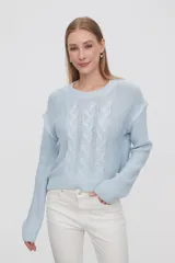 Sweater tejido de punto color celeste, con cuello redondo y diseño de trenzas en el frente.