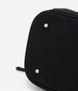 Bolso tipo maleta de tamaño grande en color negro, confeccionado en una mezcla de poliuretano y poliéster. Presenta cierres de cremallera plateados contrastantes, un bolsillo frontal con cierre y un compartimento inferior independiente con cierre. Incluye asas de mano dobles y una correa de hombro larga, ajustable y extraíble.