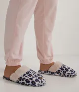 Pantufla femenina tipo chancla, cerrada en la punta, con estampado de leopardo en tonos blanco, azul marino y marrón. Presenta un borde superior de pelo sintético color beige claro.