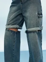 Pantalón de jean azul de corte ancho con aberturas a la altura de las rodillas.