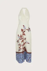 Vestido largo color blanco con estampado de flores y hojas en tonos marrones y celestes. Tiene escote halter y corte ajustado al cuerpo. Incluye cinturón fino.