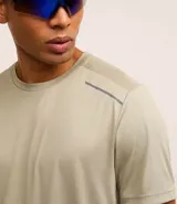 Remera deportiva gris con cuello redondo, mangas cortas, estampa heat print y detalle en los hombros. Confeccionada en tejido de malla con tecnología Dry.