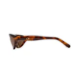 Lentes de sol envolventes color carey con lentes marrones polarizadas. El armazón es de acetato pulido y tiene el logo de la marca en las patillas.