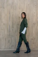 Pantalón verde con finas rayas verticales blancas, corte recto, tiro alto y bolsillos laterales.