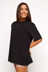 Remera negra de algodón sustentable, corte oversized, con cuello redondo y mangas cortas. Estampado frontal pequeño con la frase "pace your race".