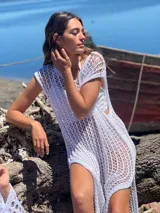 Vestido de playa blanco de crochet con mangas cortas y aberturas laterales.