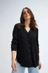 Blusa negra de manga larga con escote en V y cierre frontal con botones.