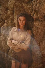 Camisa color beige de tela suave con lino, corte amplio, manga larga y cuello clásico. Presenta bordados de la bandera, el sol y un caballo en la parte delantera.