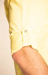 Camisa amarilla de algodón orgánico, manga larga con botones de madera, cuello italiano, calce regular, bolsillo de pecho con logo bordado.