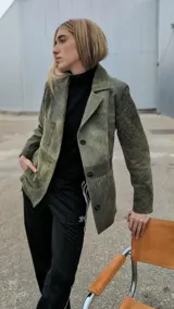 Blazer azul marino gastado de cuero ovino, con solapas de muesca, cierre frontal con botones, bolsillo de parche en el pecho y bolsillos con solapa en la parte inferior.