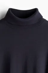 Polera azul marino de punto fino suave, con cuello alto, puños y bajo acanalados. Corte ajustado.