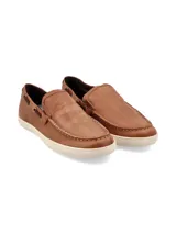 Mocasín de cuero color marrón con cordones decorativos y suela blanca.