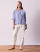 Blusa de algodón a rayas verticales en tonos celeste, rosa y blanco. Tiene cuello redondo con escote en V y abertura con botones de madera. Las mangas son 3/4 con aplique de botones.