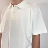 Chomba color crema con cuello polo, corte oversize y tejido acanalado vertical.