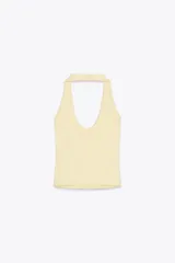 Top color crema con cuello halter y escote redondo. Espalda descubierta.