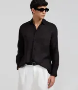 Camisa masculina de lino puro, color negro, con corte relajado, cuello inglés y manga larga con puños abotonados.