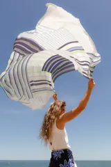 Pareo rectangular de viscosa con estampado de flores rojas sobre fondo borgoña y borde inferior con rayas verticales rojas, amarillas y blancas.