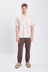 Pantalón casual marrón de lino con suave elasticidad. Corte recto con cintura ajustable con cordón.