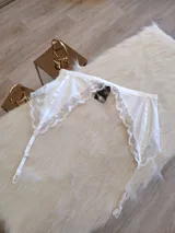 Portaligas blanco de lycra con detalles de encaje y tiras regulables.