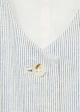 Chaleco de vestir a rayas verticales color crudo y blanco, con cuello en V, sin mangas y cierre frontal con botones.