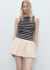 Vestido corto con cuerpo ajustado a rayas horizontales en blanco y negro, falda corta color piel con frunce en la cintura.